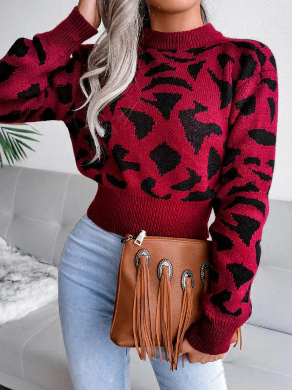 Woman wearing a red and black leopard print knit sweater with a mock neck and long sleeves.