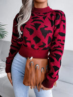 Front view of a woman wearing a red and black leopard print mock neck sweater.