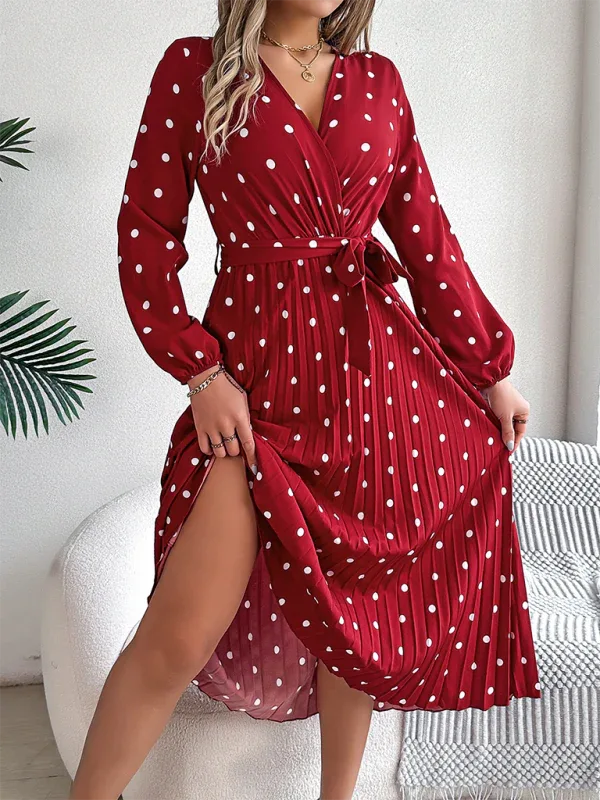 Woman wearing a red polka dot midi dress with long sleeves and a pleated skirt