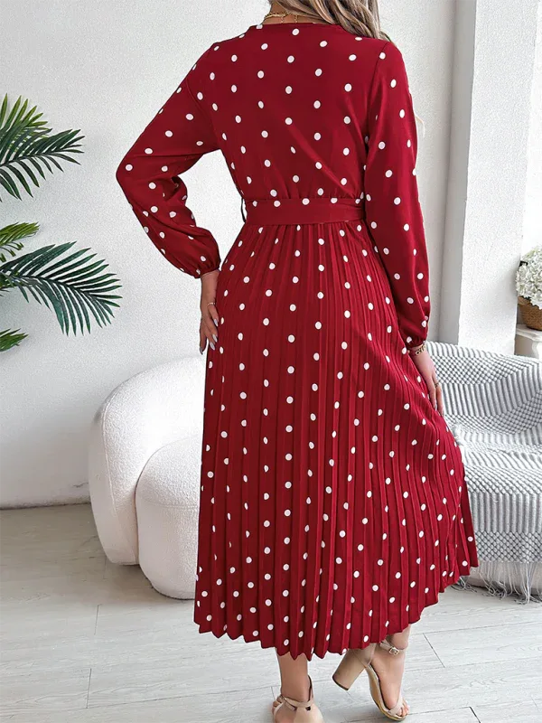 Back view of a woman in a red polka dot midi dress with a pleated skirt