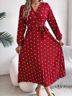 Full body shot of a woman wearing a red polka dot midi dress