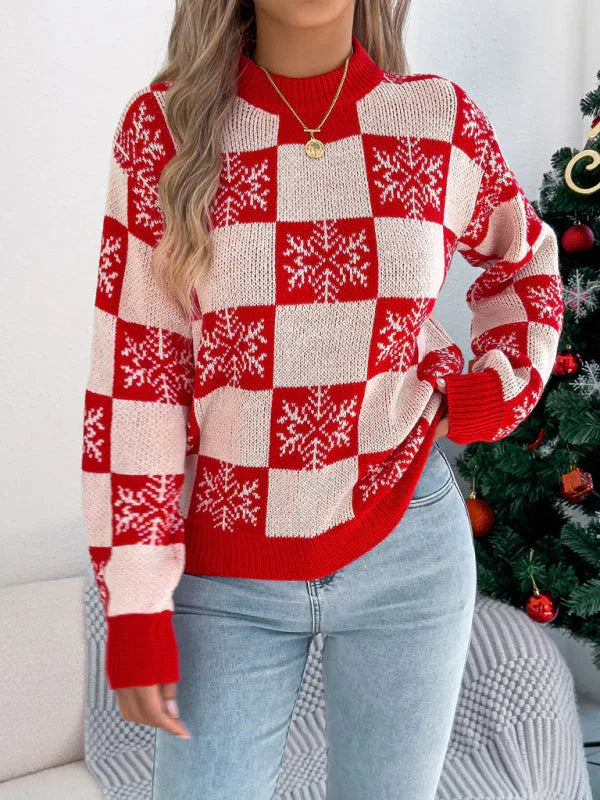 Front view of a woman wearing a red and white checkered knit sweater with snowflake print and a gold necklace