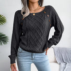 Front view of a woman in a dark grey cable knit sweater with intricate cable patterns and decorative buttons on the shoulder.