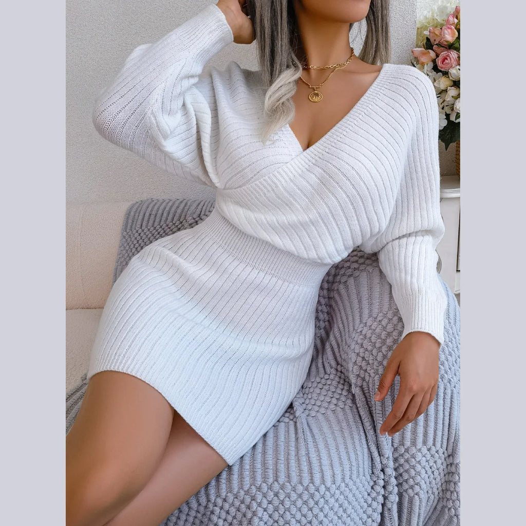 Woman posing in a white ribbed knit mini dress with batwing sleeves