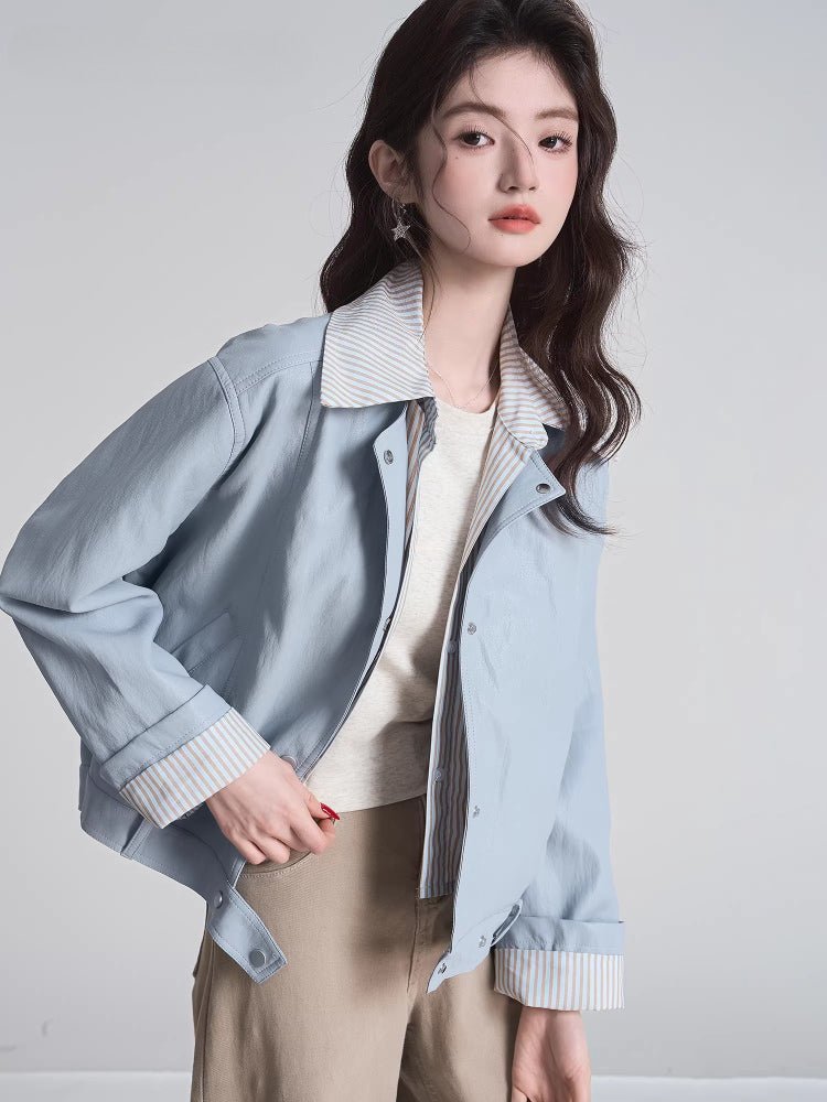 Woman posing in a light blue bomber jacket layered over a t-shirt