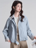 Woman wearing a light blue bomber jacket with striped lining