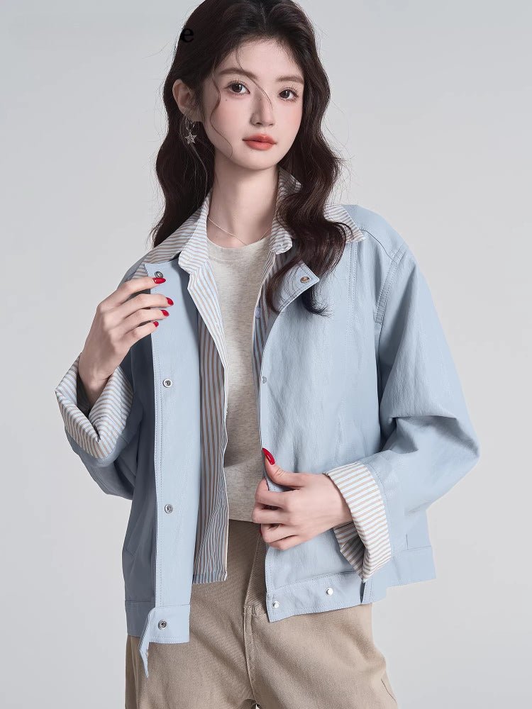Close-up of the snap button closure on the light blue bomber jacket