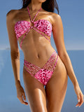 Woman wearing a pink leopard print halter bikini set with strappy details