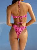 Back view of a woman in a pink leopard print halter bikini