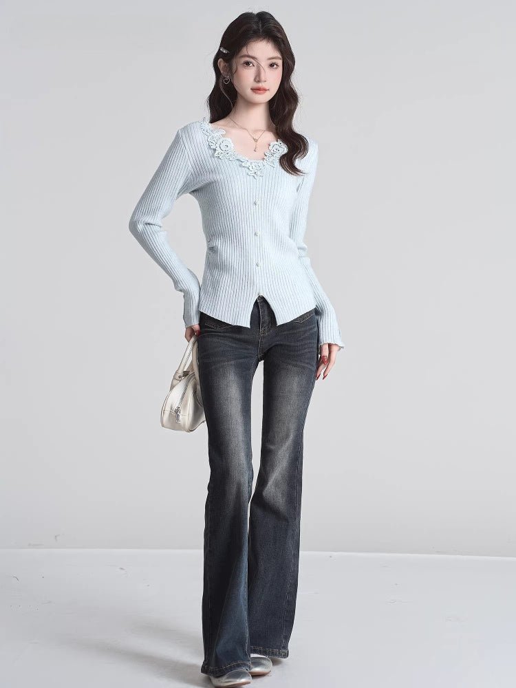Full body shot of a woman in a light blue ribbed knit cardigan and dark wash jeans