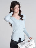 Woman posing with a newspaper while wearing the light blue cardigan