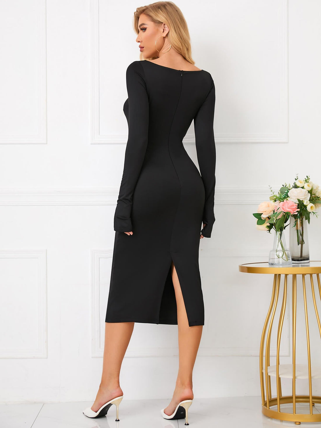 Woman wearing a black long sleeve midi dress with a keyhole neckline and bodycon silhouette.