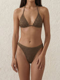 Woman wearing a textured olive green bikini set with a halter neck top and high-cut bottoms.