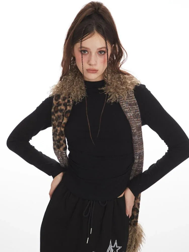 Fashion model in a black long-sleeve top and black maxi skirt with star graphics, styled with a patterned scarf