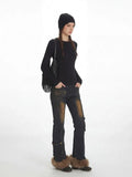 Full body shot of a woman in black knit top and stylish jeans.