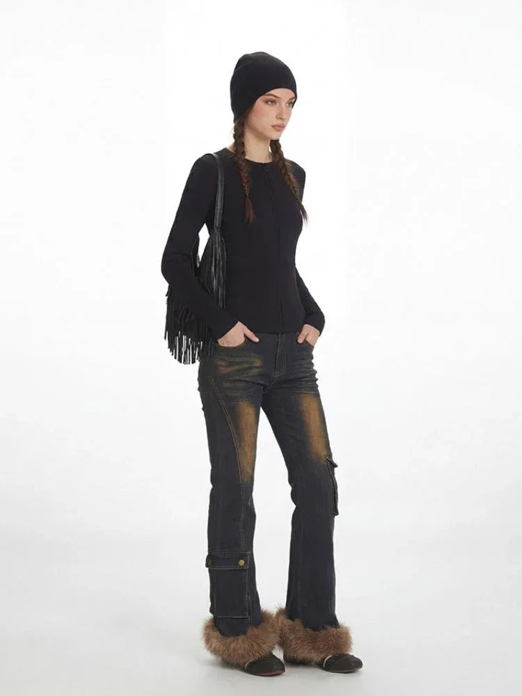 Full body shot of a woman in black knit top and stylish jeans.