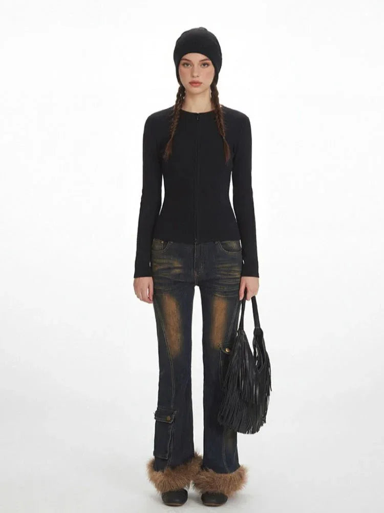 Woman wearing a black fitted knit top with a zipper closure and long sleeves.