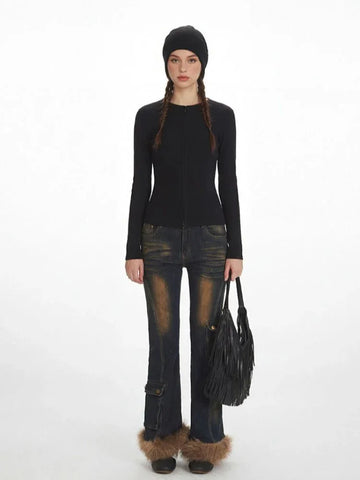 Woman wearing a black fitted knit top with a zipper closure and long sleeves.
