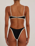 Back view of a black bikini with cream trim and adjustable straps