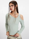 Front view detail of a light green long-sleeve ribbed knit top with asymmetrical neckline and cold shoulder cutouts.