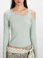Front view detail of the neckline and shoulder area of a light green long-sleeve ribbed knit top with asymmetrical design.