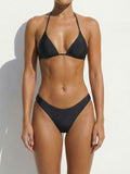 Woman wearing a black triangle bikini top and low-rise bottoms