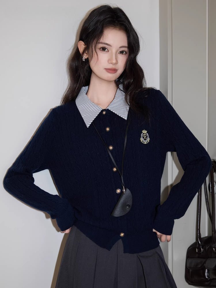 Woman posing with a navy blue cable knit cardigan layered over a striped shirt