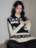 Close-up of a woman wearing a navy and cream knit zip-up vest