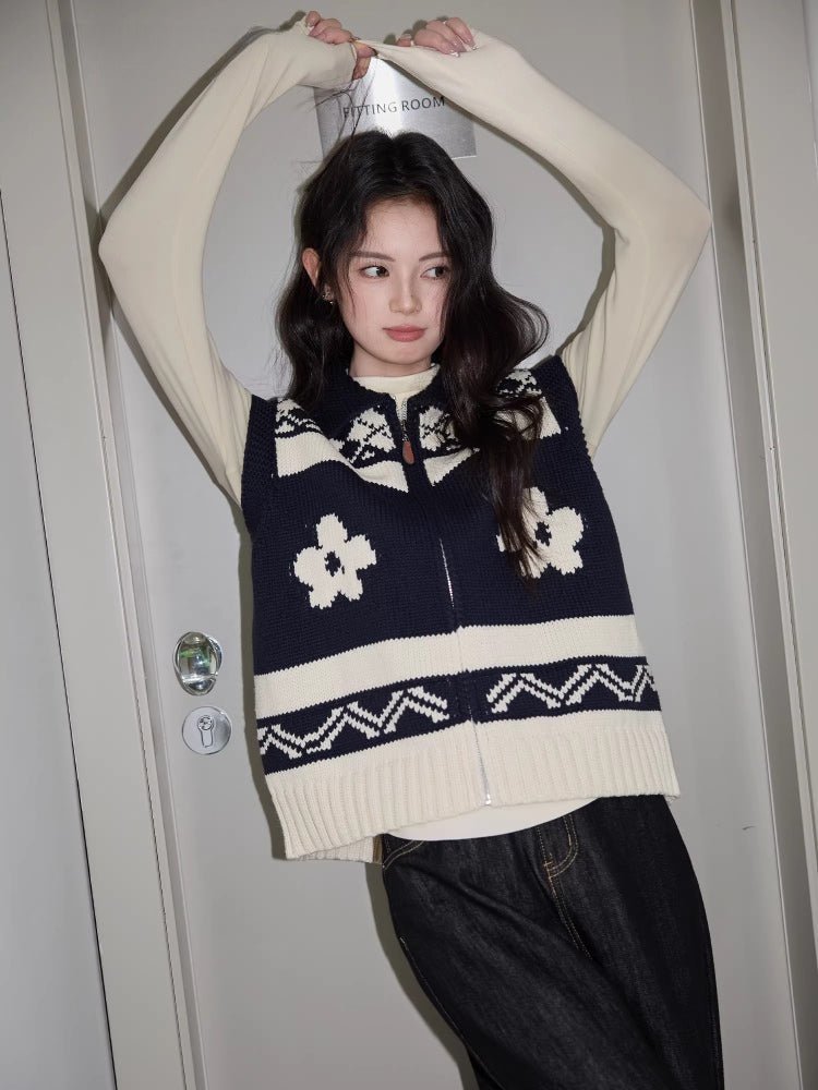 Woman wearing a navy and cream knit zip-up vest with floral pattern