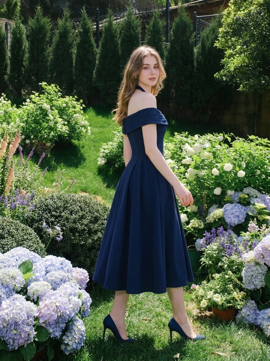 Woman in a navy blue off-the-shoulder dress in a garden setting