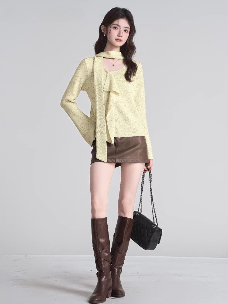 full body shot of a woman wearing a light yellow knit top and brown skirt