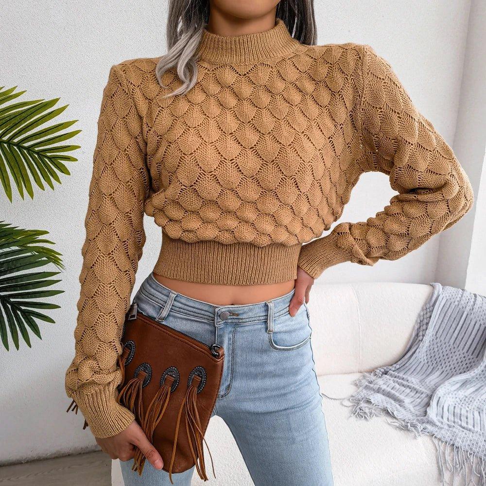 Woman wearing a tan cropped knit sweater with a mock neck and textured pattern.