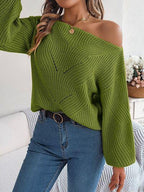 Woman wearing a green off-the-shoulder knit sweater and blue jeans