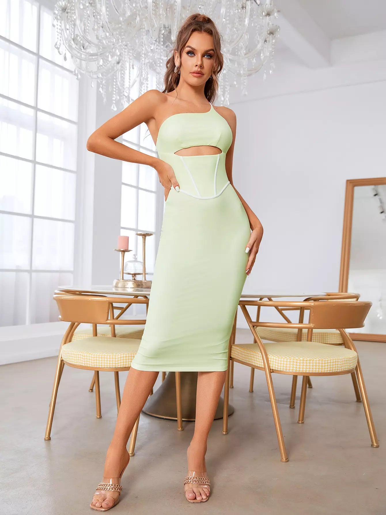 Model posing in a light green one-shoulder midi dress.