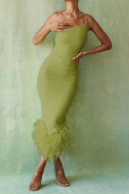 Woman wearing a lime green one-shoulder bodycon dress with feather trim hem