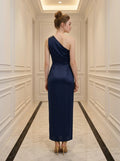 Back view of a woman in a navy blue satin one-shoulder gown with a thigh-high slit.