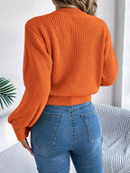 Back view of a woman in an orange knit sweater.