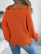 Back view of a woman wearing an orange off-the-shoulder distressed knit sweater