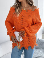 Close-up of a woman wearing an orange off-the-shoulder distressed knit sweater and holding a white clutch