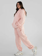 Woman wearing a pink hoodie and sweatpants set.