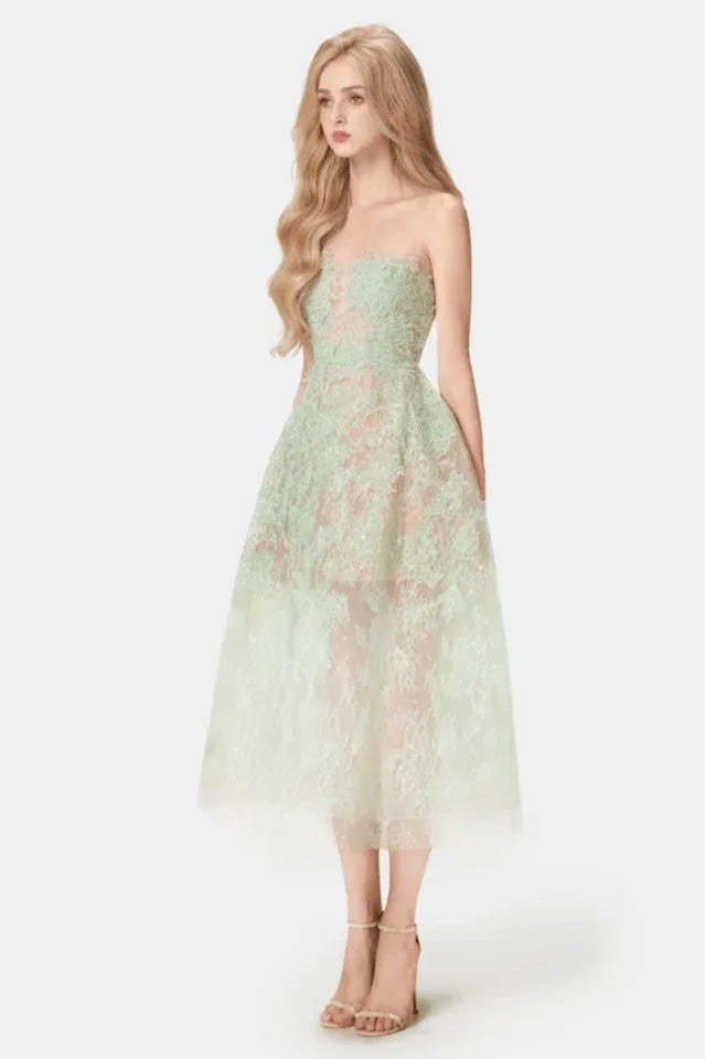 Woman in a mint green strapless lace dress with a full skirt