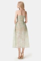 Back view of a mint green strapless lace dress with a tea-length hem