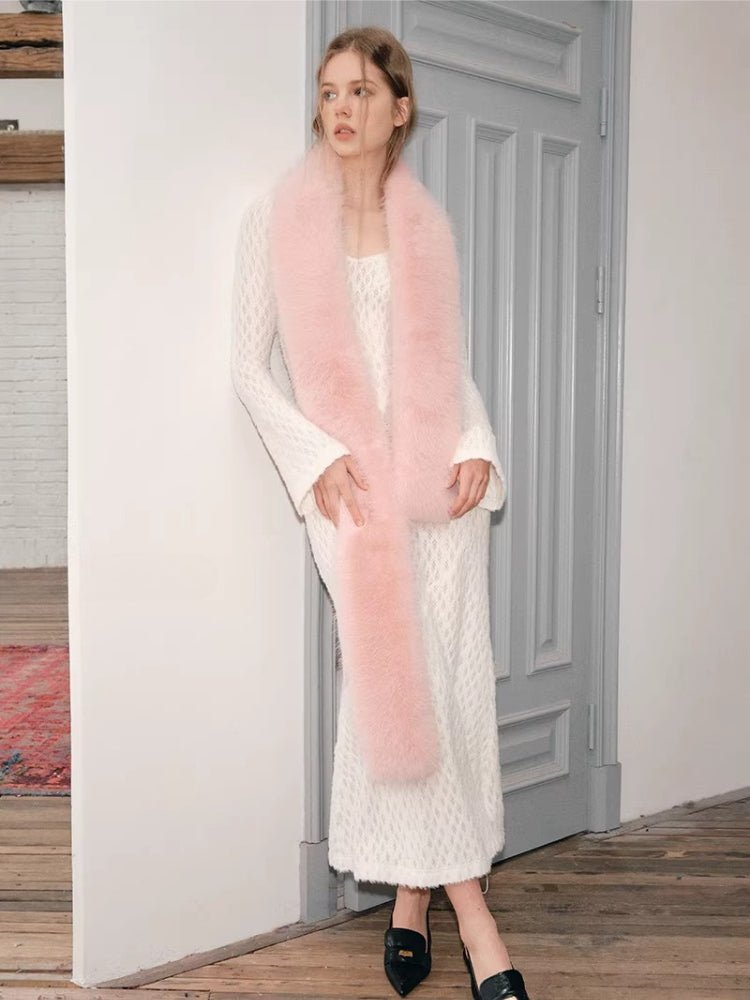 Woman posing in a white textured knit dress with a pink faux fur scarf