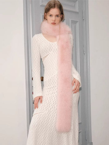 Woman wearing a white textured knit dress with a pink faux fur scarf