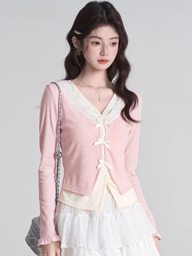 Woman wearing a pink knit cardigan with white lace trim and bow closures.