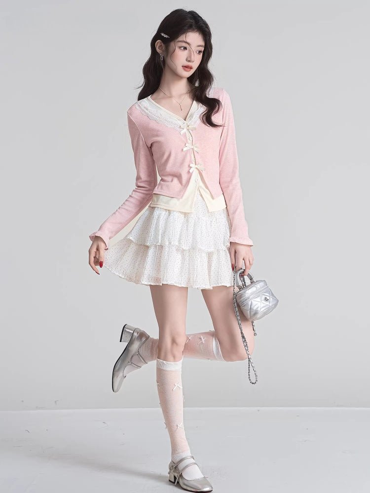 Fashionable outfit featuring a pink cardigan, layered top, and a white patterned skirt.