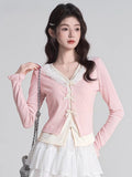 Close-up of a pink knit cardigan with delicate bow details.