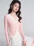 Full body shot of a woman in a pink cardigan and a white tiered skirt.