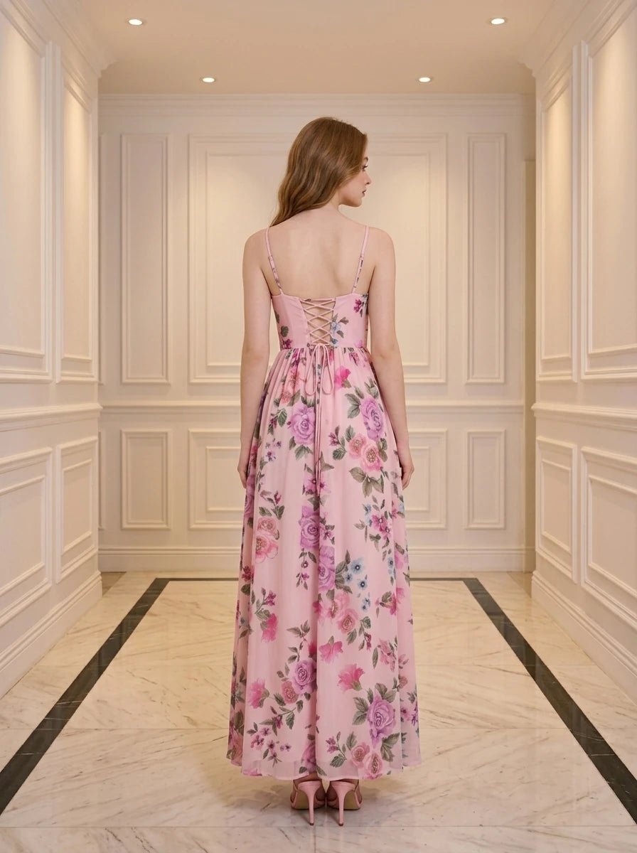Woman wearing a pink floral print maxi dress with spaghetti straps and a thigh-high slit.