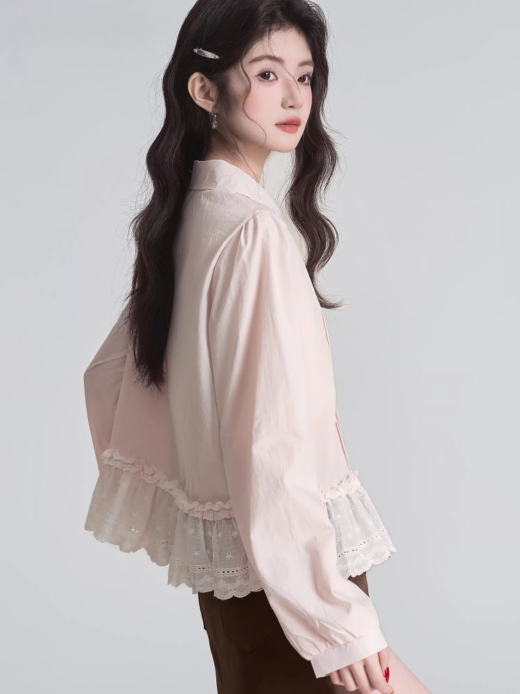 Rear view of a woman in a pink long-sleeved blouse with a ruffled lace hem.